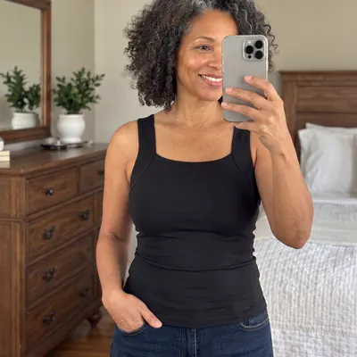 Woman taking a mirror selfie in a black tank